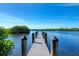 Serene waterfront dock extending over calm water, offering peaceful views of lush greenery at 875 Royal Rd, Venice, FL 34293