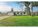 Front yard view of a charming house with a well-manicured lawn at 875 Royal Rd, Venice, FL 34293
