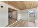 Sunroom with wood ceilings, built in bench, and views into the kitchen at 875 Royal Rd, Venice, FL 34293
