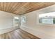 Sunroom boasts wood ceiling, built-in bench seating, and backyard access at 875 Royal Rd, Venice, FL 34293