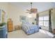 Bright bedroom with striped bedding, a ceiling fan, and plenty of natural light at 891 Norwalk Dr # 206, Venice, FL 34292