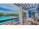 Resort-style pool and patio area with tables, chairs, and umbrellas at 1065 Gulf Of Mexico Dr # 104, Longboat Key, FL 34228