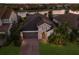 Aerial view of single-Gathering home with tile roof, paver driveway, mature trees, and water view at 12232 Perennial Pl, Lakewood Ranch, FL 34211