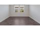 Well-lit bedroom with wood-look floors and two windows at 12232 Perennial Pl, Lakewood Ranch, FL 34211