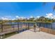 Wooden dock with metal railing overlooking a peaceful lake at 12232 Perennial Pl, Lakewood Ranch, FL 34211
