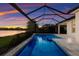 Enclosed pool with lake view at sunset at 12232 Perennial Pl, Lakewood Ranch, FL 34211
