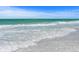 Soft waves lapping gently on a pristine, white sand beach at 1240 Dolphin Bay Way # 204, Sarasota, FL 34242