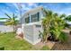 Side view of mobile home showcasing shed and tropical landscaping at 136 S Park Dr, Venice, FL 34285