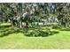 Fenced in backyard with green lawn, mature trees, and screened in patio, providing private outdoor living at 1496 Palm View Rd, Sarasota, FL 34240