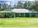 Single story home featuring a large front yard, colorful landscaping, and a well maintained green lawn at 1496 Palm View Rd, Sarasota, FL 34240