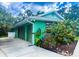 View of the two-car garage with matching doors and landscaping, under blue skies and white puffy clouds at 1496 Palm View Rd, Sarasota, FL 34240