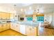 Bright kitchen with wood cabinetry, a breakfast bar, and views of the dining area at 1496 Palm View Rd, Sarasota, FL 34240