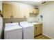 Functional laundry room with built-in cabinets and modern washer and dryer at 1496 Palm View Rd, Sarasota, FL 34240