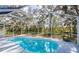 Inviting pool surrounded by a screened enclosure and lush greenery at 1496 Palm View Rd, Sarasota, FL 34240