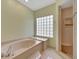 Bathroom featuring garden tub, shower, and a large window at 15903 Armistead Ln, Odessa, FL 33556