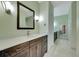 Bathroom with dark brown vanity, white countertop, and large mirror at 15903 Armistead Ln, Odessa, FL 33556