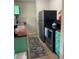Efficient galley kitchen with stainless steel appliances and teal cabinetry at 1680 17Th St, Sarasota, FL 34234