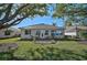 Landscaped backyard with large oak trees and patio area at 2316 Harrier Way, Nokomis, FL 34275
