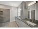 Modern bathroom with gray cabinets and a walk-in shower at 2316 Harrier Way, Nokomis, FL 34275