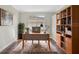 Home office with built-in shelving and hardwood floors at 2316 Harrier Way, Nokomis, FL 34275