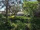 Back of house with lush landscaping and partially visible canal at 2316 Harrier Way, Nokomis, FL 34275