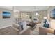 Open living room with kitchen views, hardwood floors, and ample natural light at 2316 Harrier Way, Nokomis, FL 34275