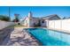 This backyard features an in-ground pool, well-maintained lawn, and a white fence at 2401 15Th W St, Palmetto, FL 34221