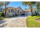 Beautiful home with stone and stucco exterior, showcasing a large driveway and lush landscaping at 24421 Tangelo Ave, Punta Gorda, FL 33980