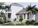 Side view of a two story home with stone accents, a walkway, and lush landscaping at 32206 Grand National Drive, Myakka City, FL 34251