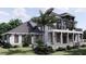 Two-story home with gray roof, white siding, stone accents, and a balcony at 32206 Grand National Drive, Myakka City, FL 34251