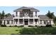 Two-story home with gray roof, white siding, stone accents, and a balcony at 32206 Grand National Drive, Myakka City, FL 34251