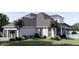 Rear view of a home with pool, gray roof, and white siding at 32206 Grand National Drive, Myakka City, FL 34251