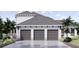 Three-car garage with gray doors and a stone facade at 32206 Grand National Drive, Myakka City, FL 34251