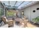 Tiled and covered patio space with wicker chairs, a table, and lush greenery at 419 Clark Dr, Holmes Beach, FL 34217