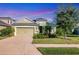 Charming single-story home featuring a two-car garage, lush landscaping, and vibrant flowers at 4239 Cottage Hill Ave, Parrish, FL 34219
