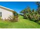 Back view of a yellow villa with a grassy backyard and landscaping at 4279 Oakhurst E Cir # 3044, Sarasota, FL 34233