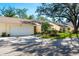 Exterior view of a yellow villa with a white garage door and green lawn at 4279 Oakhurst E Cir # 3044, Sarasota, FL 34233