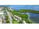 Aerial view of waterfront condo building with lush landscaping and tennis courts at 4540 Gulf Of Mexico Dr # 304, Longboat Key, FL 34228