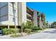 Condo building exterior with palm trees and a paved pathway at 4540 Gulf Of Mexico Dr # 304, Longboat Key, FL 34228