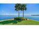 Scenic waterfront view with lush lawn and palm trees at 4540 Gulf Of Mexico Dr # 304, Longboat Key, FL 34228