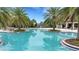 Community pool with plenty of lounge chairs and palm trees at 5435 Tripoli Dr, Palmetto, FL 34221