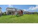 Wide backyard shot features a playset, swing set, well maintained lawn and screened in patio at 5548 Summit Gln, Bradenton, FL 34203