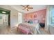 Main bedroom with pink walls, floral bedding, and large window at 5548 Summit Gln, Bradenton, FL 34203