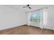 Minimalist bedroom featuring wood floors, a ceiling fan, and a large window with backyard views at 5548 Summit Gln, Bradenton, FL 34203
