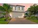 Charming two-story home showcasing a well-manicured lawn, lush landscaping, and a spacious two-car garage at 5548 Summit Gln, Bradenton, FL 34203