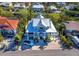 Aerial view of a two-story home with metal roof, large porch, and surrounding tropical landscape at 598 Lyons Ln, Longboat Key, FL 34228