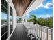 Outdoor balcony with white chairs and a table, offering scenic views at 598 Lyons Ln, Longboat Key, FL 34228