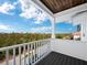 Spacious balcony overlooking lush greenery and distant water views at 598 Lyons Ln, Longboat Key, FL 34228