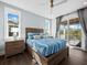 Bright bedroom with a wooden bed frame and access to a private balcony at 598 Lyons Ln, Longboat Key, FL 34228