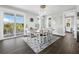 Elegant dining room with a wooden table, white chairs, and access to a balcony at 598 Lyons Ln, Longboat Key, FL 34228